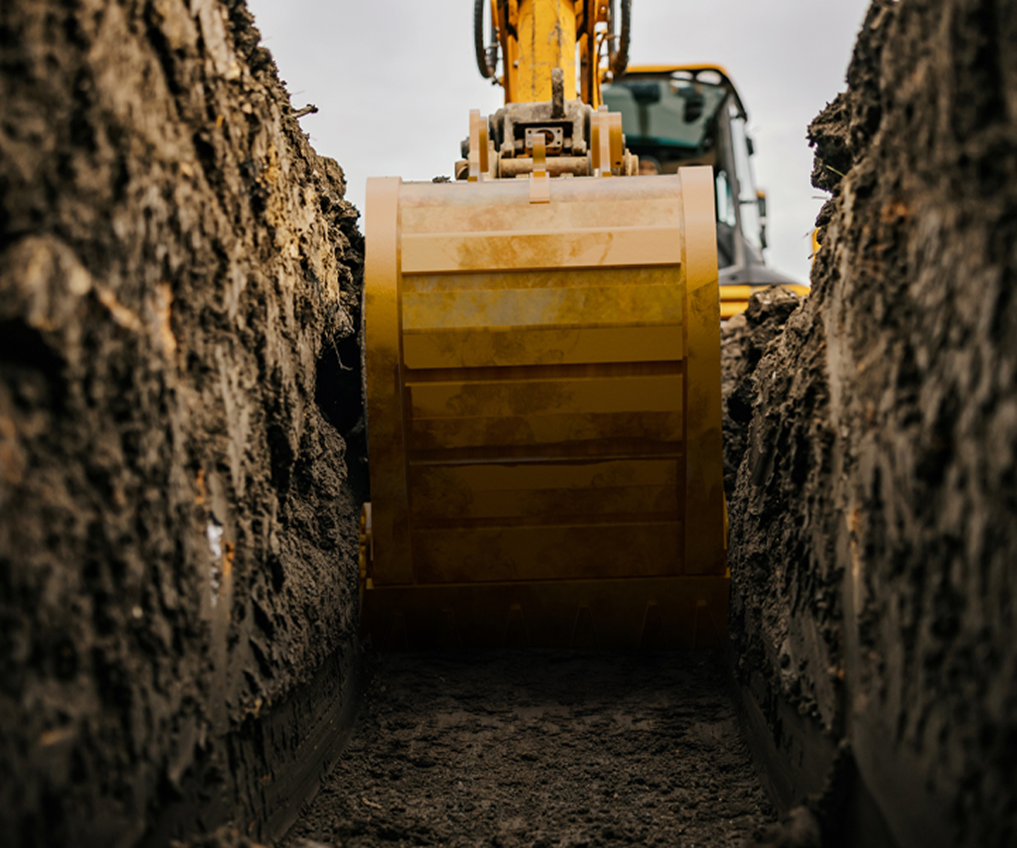 Excavator bucket digging a trench