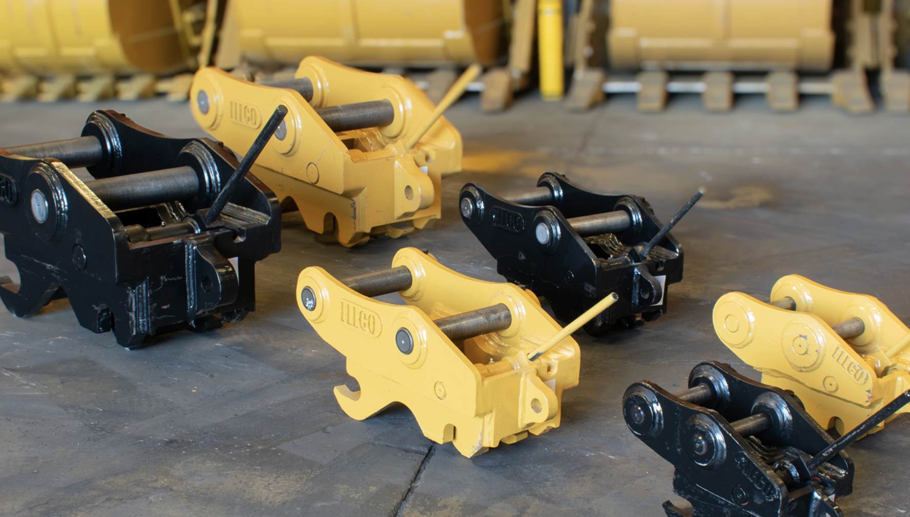 Row of FLECO manual and hydraulic quick couplers in yellow and black