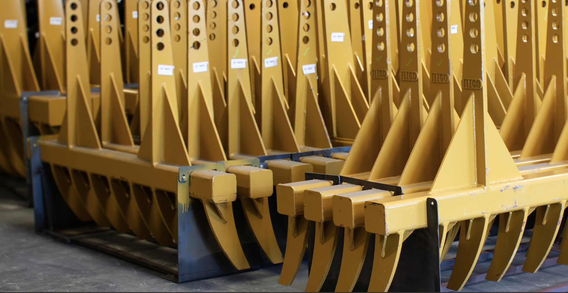 Rows of yellow FLECO rakes staged in the warehouse